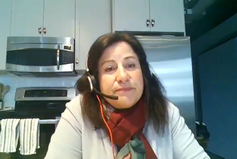 An image of Hamilton City Manager Janette Smith in her home kitchen wearing a computer headset during a video conference with the Hamilton Chamber of Commerce