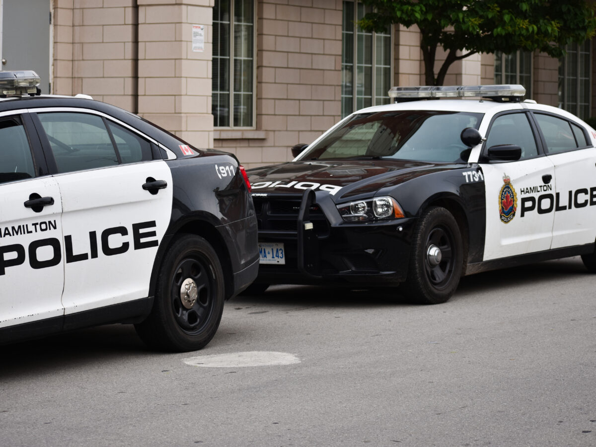 Two Hamilton Police Cruiser cars on a street.