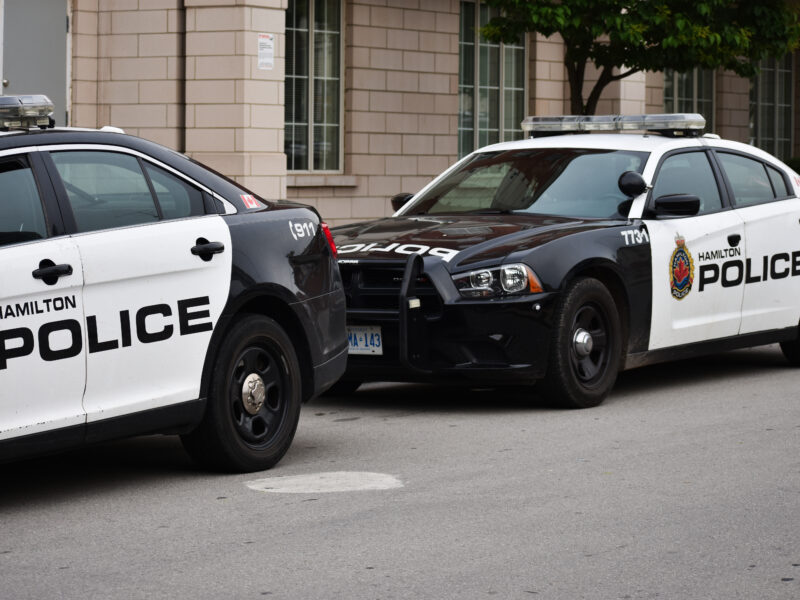 Two Hamilton Police Cruiser cars on a street.