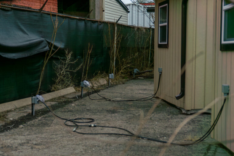 Electrical meter and wiring installations on the exterior of HATS community structures at 205 Cannon Street East.