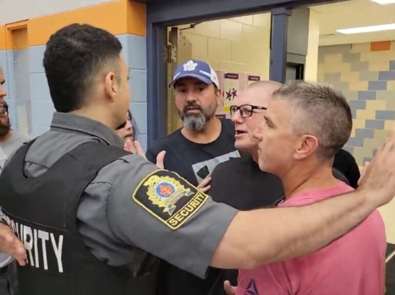 Three men in a confrontation with a City of Hamilton security guard just prior to the cancellation of a planned public meeting regarding tiny homes in the North End.