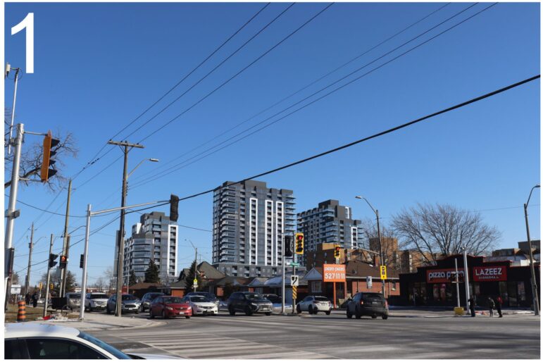 A photorealistic architectural rendering of a busy street intersection in Hamilton under a clear blue sky. In the background, three modern high-rise buildings with dark grey and white facades stand behind existing commercial properties, including a Pizza Pizza and Lazeez Shawarma. Cars are visible at the intersection in the foreground.