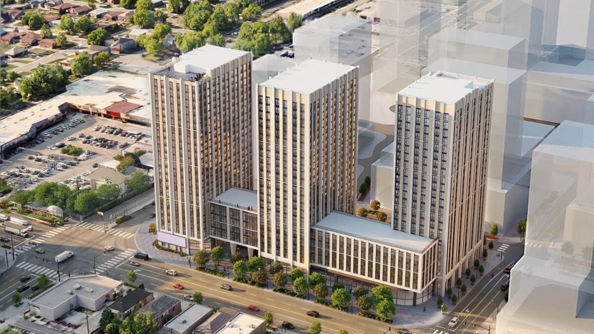 An aerial, bird's-eye architectural rendering displays a proposed mixed-use complex featuring three contemporary high-rise residential towers rising from connected multi-storey podium structures. The buildings exhibit light-coloured stone or precast cladding panels contrasted by vertical strips of dark-framed windows and rectangular balconies, with green rooftop terraces situated on the podium levels. The complex is situated at a busy urban intersection flanked by multiple lanes of vehicle traffic, a suburban commercial plaza parking lot to the left, and low-rise residential neighbourhoods stretching into the distance. Ghosted, semi-transparent grey geometric blocks are positioned to the right to simulate future phase build-outs under clear, artificial daylight conditions designed for urban planning assessment.